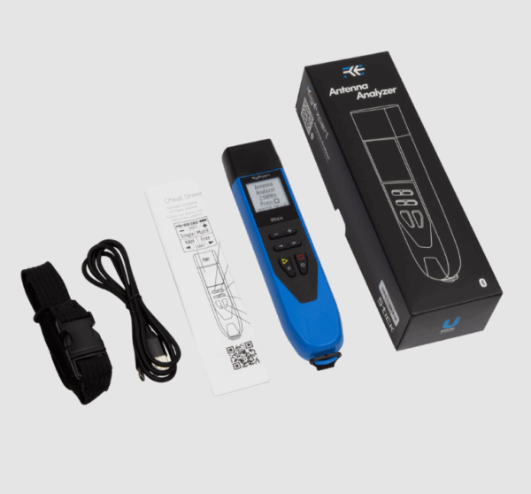 Portable antenna analyzer with display, cables, and instruction manual.