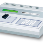 White IC tester device with green display screen and numeric keypad interface.