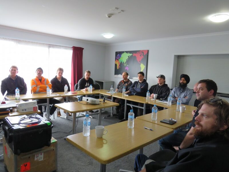 Group training session with participants seated around tables in a classroom setting.
